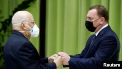 El Viceprimer Ministro de Rusia, Yuri Borisov (D), saluda a su homólogo cubano, Ricardo Cabrisas, en La Habana, Cuba, el 31 de marzo de 2021.