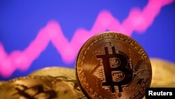 FILE - A representation of virtual currency bitcoin is seen in front of a stock graph in this illustration taken Jan. 8, 2021.