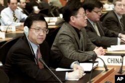资料照：2001年12月19日星期三，中国首席贸易谈判代表龙永图（最左边）出席在瑞士日内瓦举行的世界贸易组织总理事会会议。中国作为世界贸易组织的新成员首次参加了这次会议。