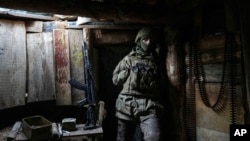 A Ukrainian serviceman stands in a shelter on a position at the line of separation between Ukraine-held territory and rebel-held territory near Zolote, Ukraine, Feb. 19, 2022. 