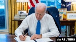 （资料照片）2022年2月21日美国总统拜登在白宫签署行政命令，禁止美国个人与被俄罗斯承认为独立的乌克兰东部两个分离地区之间的贸易和投资。