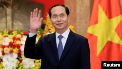  FILE - Vietnamese President Tran Dai Quang greets journalists as he waits for the arrival of Russian Foreign Minister Sergei Lavrov at the Presidential Palace in Hanoi, Vietnam, March 23, 2018.