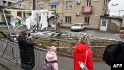 Ljudi se okupljaju oko ostataka granate, u Kijevu, 24. februara 2022.