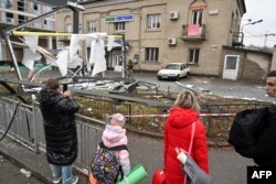 ពលរដ្ឋឈរ​មើល​កន្លែង​ត្រូវ​អាជ្ញាធរ​បិទ​មួយ​កន្លែង​ដែល​មាន​បំណែក​គ្រាប់​រ៉ុក្កែតនៅ​តាម​ដង​ផ្លូវ​នៃ​រដ្ឋធានីកៀវ​ប្រទេស​អ៊ុយក្រែន​ កាល​ពី​ថ្ងៃ​ទី​២៤ ខែ​កុម្ភៈ​ឆ្នាំ​២០២២ ក្រោយ​ប្រធានាធិបតី​រុស្ស៊ី​លោក Vladimir Putin បាន​ប្រកាស​ពី​ការ​វាយប្រហារ​យោធា។ (AFP)