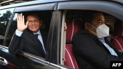 លោក កឹម សុខា អតីត​មេដឹកនាំ​គណបក្ស​សង្គ្រោះជាតិ​ដែល​ត្រូវ​បាន​តុលាការ​រំលាយ កំពុង​ជិះ​រថយន្ដ​ធ្វើ​ដំណើរ​ទៅ​កាន់​សាលា​រាជធានី​ភ្នំពេញ​ដើម្បី​ចូលរួម​សវនាការ​កាត់​ក្ដី​លោក​ពី​បទ​ក្បត់ជាតិ​ រាជធានី​ភ្នំពេញ ថ្ងៃទី១៩ ខែមករា ឆ្នាំ២០២២។ (TANG CHHIN Sothy / AFP) 