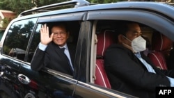 លោក កឹម សុខា អតីត​មេដឹកនាំ​គណបក្ស​សង្គ្រោះជាតិ​ដែល​ត្រូវ​បាន​តុលាការ​រំលាយ កំពុង​ជិះ​រថយន្ដ​ធ្វើ​ដំណើរ​ទៅ​កាន់​សាលា​រាជធានី​ភ្នំពេញ​ដើម្បី​ចូលរួម​សវនាការ​កាត់​ក្ដី​លោក​ពី​បទ​ក្បត់ជាតិ​ រាជធានី​ភ្នំពេញ ថ្ងៃទី១៩ ខែមករា ឆ្នាំ២០២២។ (TANG CHHIN Sothy / AFP) 