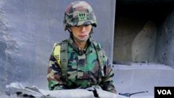 Soldado surcoreano enseña los fragmentos de las armas disparadas por Corea del Norte a la isla fronteriza de Yeonpyeong.