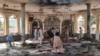 People view the damage inside of a mosque following a bombing in Kunduz, province northern Afghanistan, Oct. 8, 2021.