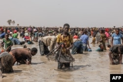 A young man carries his fishing net during the Sanke mon collective fishing rite in San, Sego Region on June 6, 2024. (Photo by OUSMANE MAKAVELI / AFP)
