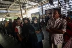 Passengers queue to refund their tickets during a major power blackout at a commuter train station in Jakarta, Indonesia, Aug. 4, 2019. (Antara Foto/Fakhri Hermansyah)