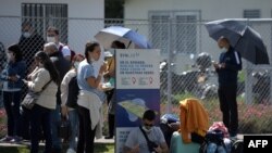 Un grupo de personas esperan ser probadas contra COVID-19 afuera del Aeropuerto Internacional El Dorado en Bogotá, el 31 de diciembre de 2021, en medio de un aumento de casos debido a la variante ómicron.