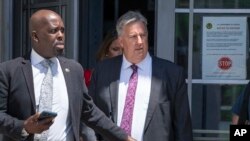El abogado del expresidente Donald Trump, James Trusty (derecha), sale del edificio del Departamento de Justicia, el lunes 5 de junio de 2023, en Washington. (AP Foto/Jacquelyn Martin)
