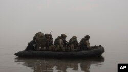 資料照片：2023年10月14日，烏克蘭陸戰隊員在赫爾松附近前線渡過第聶伯河。 (美聯社照片）