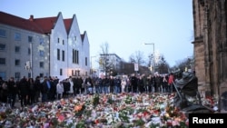 Watu wengi wajitokeza kuweka maua na mishuma kwenye eneo la shambulizi la gari kwenye soko la Christmas, Disemba 22, 2024. Picha ya Reuters