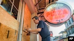 صاحب یک رستوران در نیواورلئان در آستانه از راه رسیدن توفان آیدا پنجره‌های رستورانش را با تخته می‌پوشاند - ۶ شهریور ۱۴۰۰