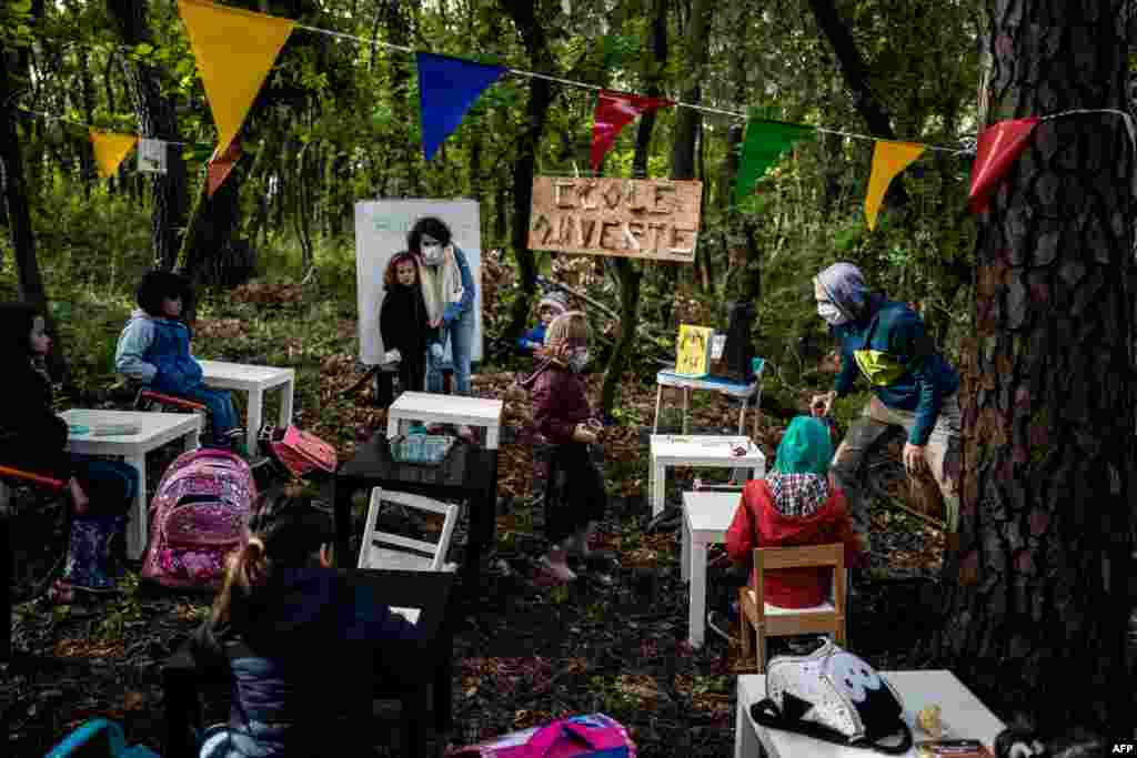 Children attend a class in the forest near Upie, France. - Some childen went to "school" again in oak and pine trees with parents acting as teachers, to protest against the non-reopening of the school in the village.