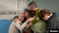 Fernando Simon Marman y Louis Har, dos rehenes israelíes que, según el ejército israelí, fueron liberados en una operación de fuerzas especiales en Rafah, Gaza, se reúnen con sus seres queridos en Sheba Medical Center, en Ramat Gan, Israel, 12 de febrero de 2024.