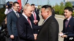 Ruski predsednik Vladimir Putin rukuje se sa severnokoreskim liderom Kim Džong Uom, tokom njihovog sastanka na kosmodromu u Vosočniju, Rusija, 13. septembra 2023.