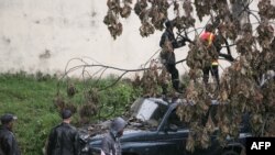 Wafanyakazi wa zimamoto wakijaribu kuondoa mti ulioanguka kwenye gari kutokana na kimbunga Enawo mjini Antananarivo, Madagascar, Machi 8, 2017. Picha ya AFP