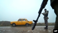 A car is stopped at a checkpoint manned by Ukrainian police officers, in Berdyansk, south coast of Azov sea, eastern Ukraine, Nov. 27, 2018. 