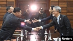 ប្រធានការិយាល័យ​សិល្ប​សម្តែង​លោកនៃ​ក្រសួង​វប្បធម៌​កូរ៉េ​ខាងជើង​ចាប់ដៃ​ជាមួយ​លោក Lee Woo-sung គណប្រតិភូ​កូរ៉េ​ខាង​ត្បូង​បន្ទាប់ពី​ចប់​កិច្ច​ប្រជុំ​ Tongilgak។