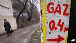 FILE - As Russian-Ukranian billing dispute leaves over 15 European nations scrambling for alternative sources, woman walks past gas metering point in Chisinau, Moldova, Jan. 16, 2009.