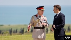 Britanski kralj Čarls III (L) i francuski predsjednik Emmanuel Makron razgovaraju tokom komemorativne ceremonije Kraljevske britanske legije povodom obilježavanja 80. godišnjice iskrcavanja saveznika „Dan D” u Drugom svjetskom ratu u Normandiji.