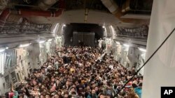 Ciudadanos afganos son transportados desde el Aeropuerto Internacional Hamid Karzai en Afganistán, el domingo 15 de agosto de 2021.