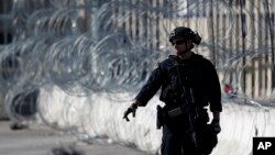 Tokom vežbe, pripadnici Carine i granične zaštite zaustavljaju saobraćaj na prilazu graničnom prelazu u San Jsidro, 10. januara 2019, viđeno iz Tihuane, Meksiko.