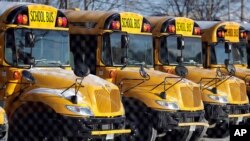 FILE - School buses are parked at the Skokie School District 68 parking lot in Skokie, Ill.