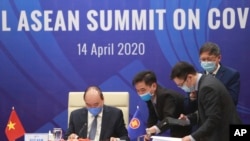 Vietnamese Prime Minister Nguyen Xuan Phuc, left, and his staff prepare documents ahead of the Special ASEAN summit on COVID-19 in Hanoi, Vietnam Tuesday, April 14, 2020. ASEAN leaders met with their counterparts from China, Japan and South Korea.