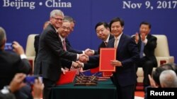 Business leaders shake hands during signing ceremony attended by U.S. President Donald Trump and China's President Xi Jinping at the Great Hall of the People in Beijing, Nov. 9, 2017.