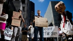 Protesters demonstrate across the street from the Comcast Center Monday, Sept. 15, 2014, in Philadelphia. Demonstrators opposed the proposed merger of Comcast Corp. and Time Warner Cable Inc., and called for support of "net neutrality." (AP Photo/Matt Rourke)