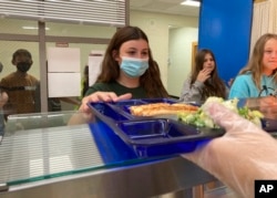Students get lunch of homemade pizza and caesar salad at the Albert D. Lawton Intermediate School, in Essex Junction, Vt., Thursday, June 9, 2022. (AP Photo/Lisa Rathke)