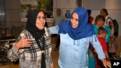 Hanadi Al-Haj(der.) saluda a su madre Amal Bagoon que llega de Yemen, en el Aeropuerto Internacional de Los Angeles. Amal llegó de Jordania, vía Estambul.