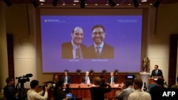 Thomas Perlmann, le secrétaire du Comité Nobel, à côté d'un écran affichant les lauréats du Prix Nobel de physiologie ou médecine 2021 David Julius et Arden Patapoutian, lors d'une conférence de presse à l'Institut Karolinska de Stockholm, le 4 octobre 2021.