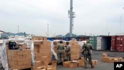 ARCHIVO - En esta fotografía publicada por la Secretaría de Marina de México, marinos revisan un cargamento de botellas etiquetadas como mezcal en Manzanillo, México, el sábado 22 de julio de 2023. 