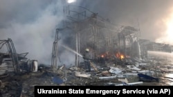 Firefighters work to extinguish a fire at a market hit by shelling in Kharkiv, Ukraine, March 16, 2022. 