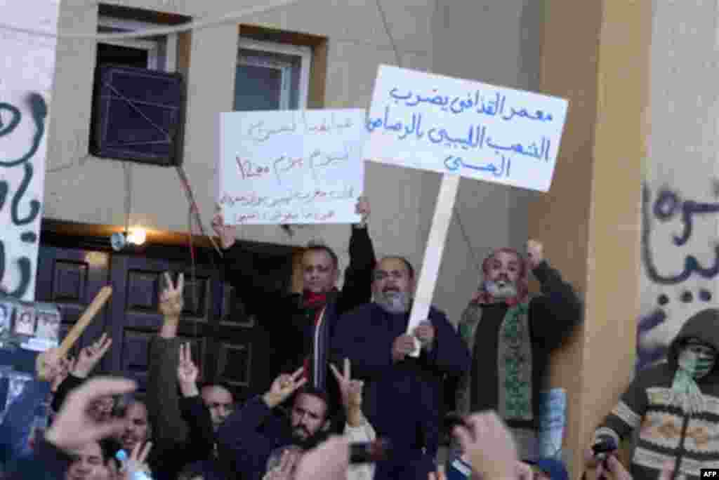 This photograph, obtained by The Associated Press outside Libya and taken by an individual not employed by AP, shows people shouting and holding signs during recent days' unrest in Benghazi, Libya. Placards in arabic read at center left "Come on, Come on,