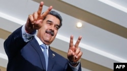 El presidente Nicolás Maduro saluda con los signos de victoria en una cumbre de líderes suramericanos en Brasilia, el 30 de mayo de 2023.
