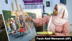 Somali artist Sana Ashraf Sharif Muhsin, 21, works on one of her paintings at her home in the capital Mogadishu, Somalia Friday, Oct. 15, 2021. (AP Photo/Farah Abdi Warsameh)