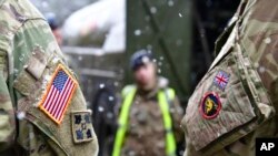 资料照片：在德国布吕克举行的有关“捍卫者-2020“演习的一次记者会后，美英军人并肩站立。(2020年2月26日)