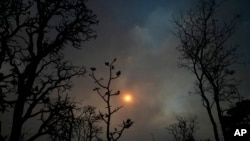 ARCHIVO - Se pone el sol detrás del humo de incendios en el bosque del Cerrado en Brasilia, 5 de setiembre de 2022. 