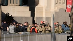 Oficiales de policía tienen una conversación en el lugar del tiroteo durante el desfile de los Chiefs de Kansas City tras su victoria en el Super Bowl el miércoles 14 de febrero del 2024.