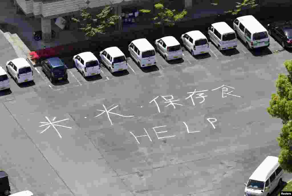"Rice, Water, Preserved Food and HELP'" written on the ground at a welfare center for the aged after an earthquake in Mifune town, Kumamoto prefecture, southern Japan, in this aerial view photo taken by Kyodo, April 17, 2016.