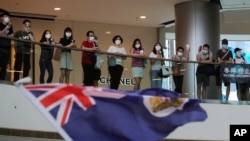 Protesters sing "Glory to Hong Kong" and wave a Hong Kong colonial flag in a shopping mall during a protest against China's national security legislation for the city, in Hong Kong, Friday, May 29, 2020.