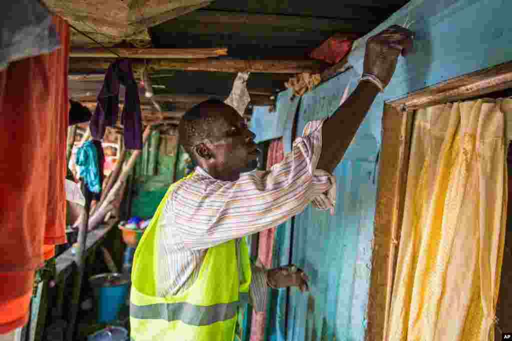 A health worker volunteer marks a home with chalk to identify that it has been visited, as they distribute bars of soap and information about Ebola in Freetown, Sierra Leone, Sept. 20, 2014.