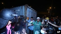 ภาพการเผชิญหน้าระหว่างผู้ชุมนุมและตำรวจควบคุมฝูงชน ระหว่างการเดินขบวนของประชาชนไปยังบ้านพักของ พล.อ.ประยุทธ์ จันทร์โอชา นายกรัฐมนตรี ณ ขณะนั้น เมื่อเดือนกุมภาพันธ์ 2021 (ที่มา: แฟ้มภาพ/AP)