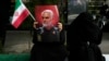 Manifestante sostiene un cartel del difunto general iraní Qassem Soleimani, que murió en un ataque con aviones no tripulados estadounidenses en 2020, durante una manifestación frente a la antigua embajada de EEUU en Teherán, Irán, el sábado 4 de noviembre de 2023.