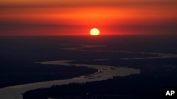 FILE - Ships travel along the Mississippi River in LaPlace, La., as the sun sets on Oct. 20, 2023. The nation’s rivers and streams remain stubbornly polluted with nutrients that contaminate water, according to a recently released Environmental Protection Agency assessment. 